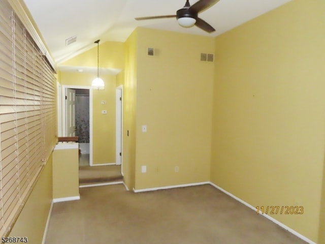 carpeted empty room with ceiling fan and lofted ceiling