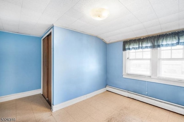 interior space featuring a baseboard radiator and vaulted ceiling