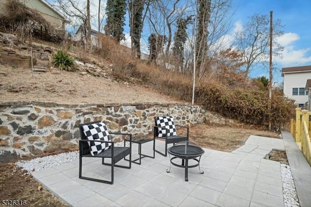 view of patio with an outdoor fire pit and fence