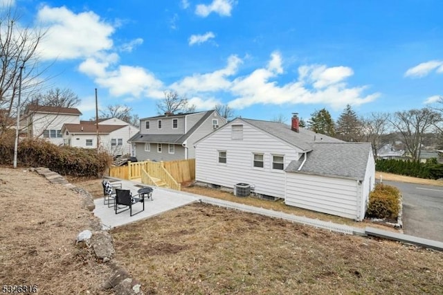 rear view of property with a patio, cooling unit, fence, a residential view, and a chimney