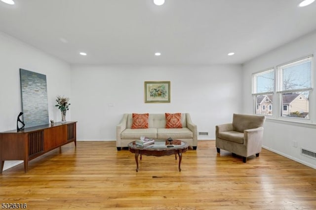 living area with visible vents, light wood-style flooring, and recessed lighting