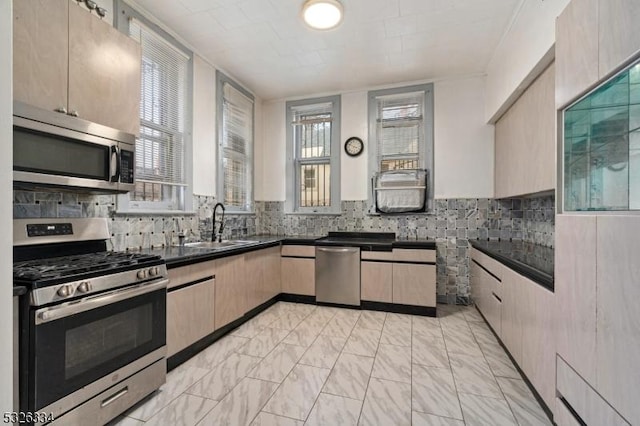 kitchen with light brown cabinets, sink, appliances with stainless steel finishes, and tasteful backsplash