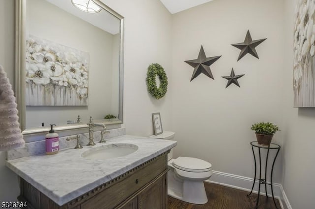 bathroom with toilet, vanity, and hardwood / wood-style flooring