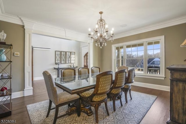 dining room with decorative columns, a notable chandelier, dark hardwood / wood-style floors, and ornamental molding