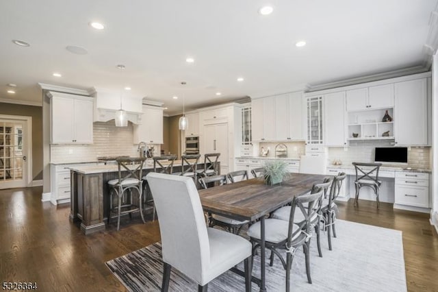 dining space with crown molding and dark hardwood / wood-style flooring