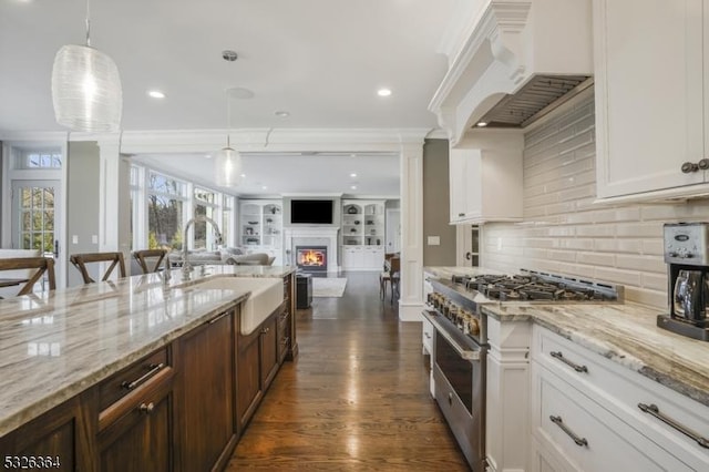 kitchen featuring crown molding, high end stainless steel range, dark hardwood / wood-style floors, decorative light fixtures, and white cabinetry