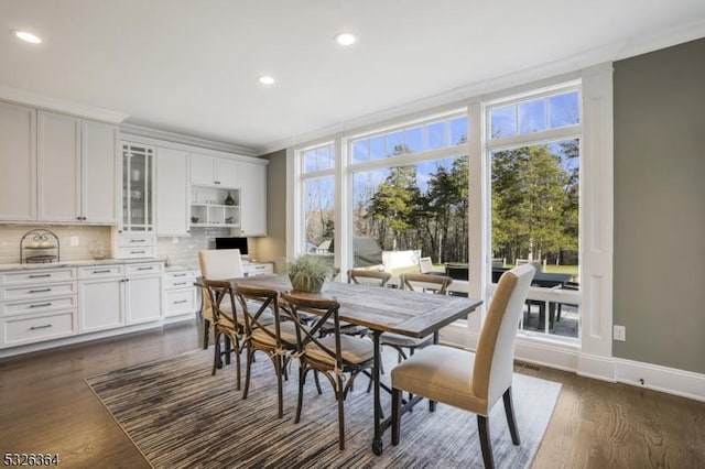 dining room with dark hardwood / wood-style floors, crown molding, and a wealth of natural light