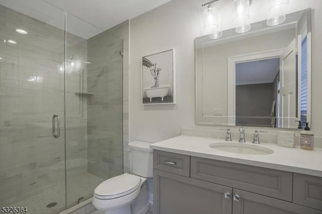 bathroom with vanity, toilet, and a shower with shower door