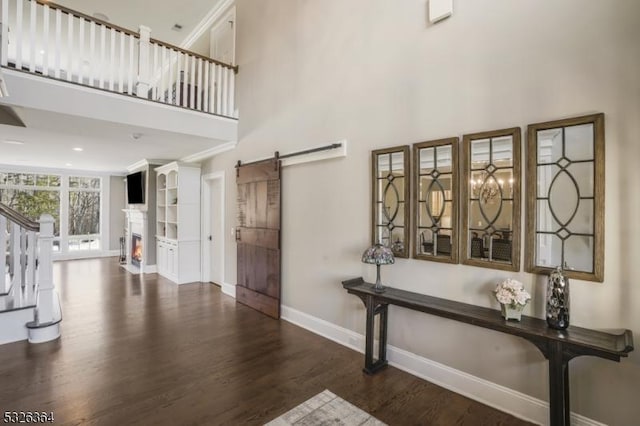 entryway with a high ceiling, a barn door, and dark hardwood / wood-style floors