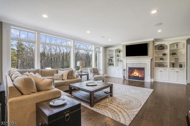 living room with dark wood-type flooring, built in features, and ornamental molding