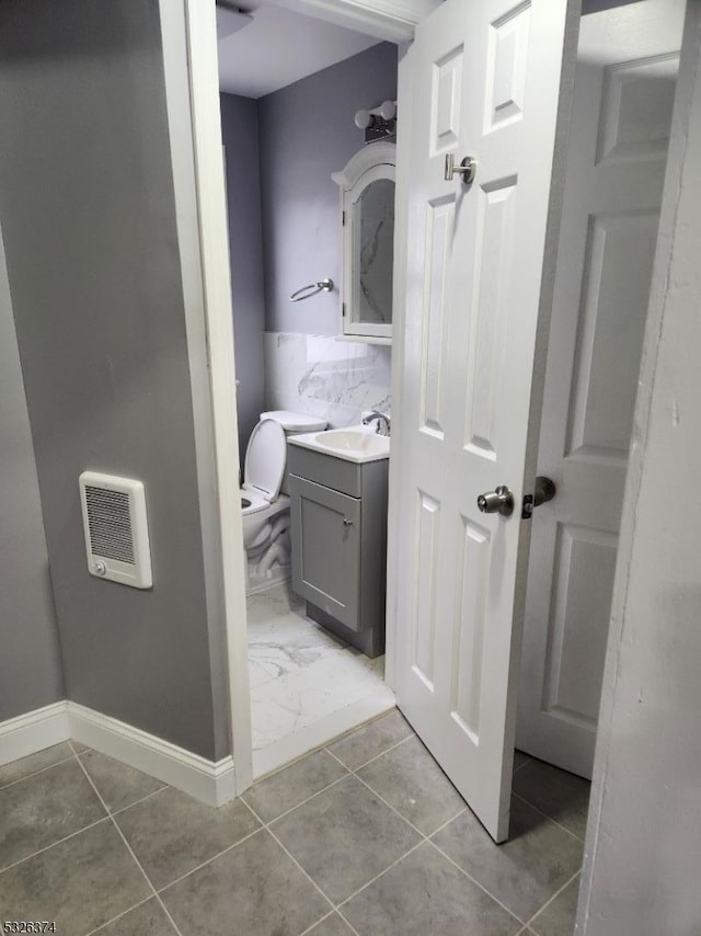 bathroom with vanity, tasteful backsplash, and toilet