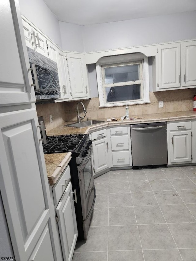 kitchen with backsplash, white cabinetry, sink, and appliances with stainless steel finishes