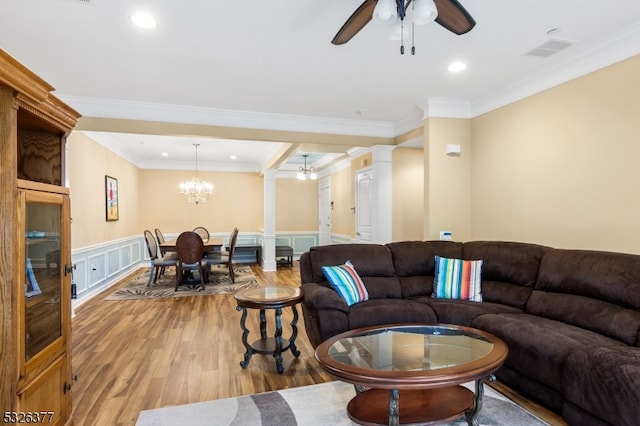 living room featuring ceiling fan with notable chandelier, light hardwood / wood-style floors, ornate columns, and crown molding