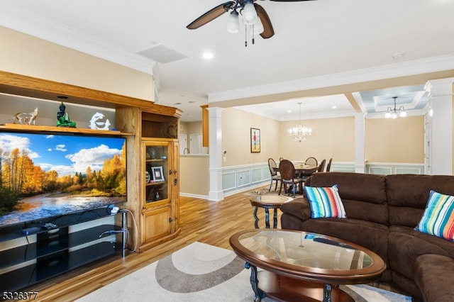 living room with ceiling fan with notable chandelier, light hardwood / wood-style floors, and crown molding