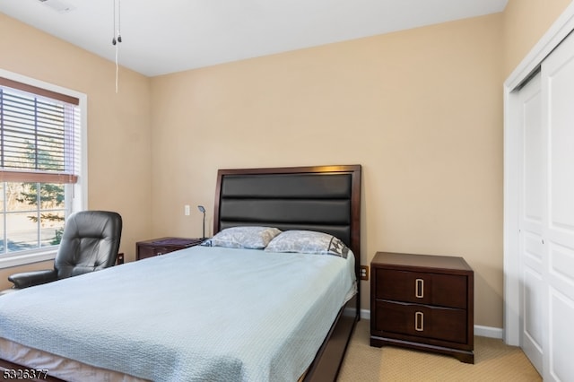 bedroom with light colored carpet and a closet