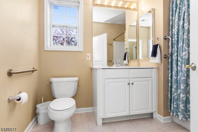 bathroom with tile patterned floors, vanity, toilet, and walk in shower