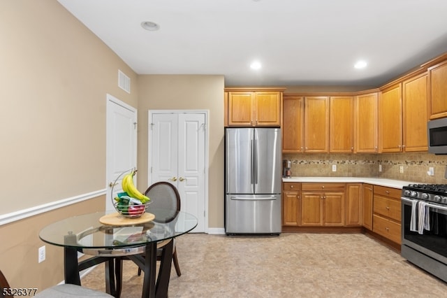 kitchen with tasteful backsplash and appliances with stainless steel finishes