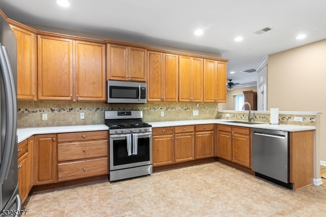 kitchen featuring ceiling fan, sink, decorative backsplash, and stainless steel appliances