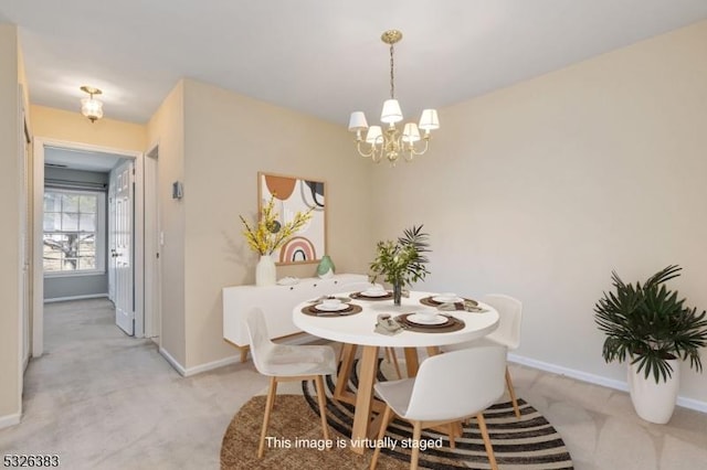 dining space featuring baseboards, a chandelier, and light carpet