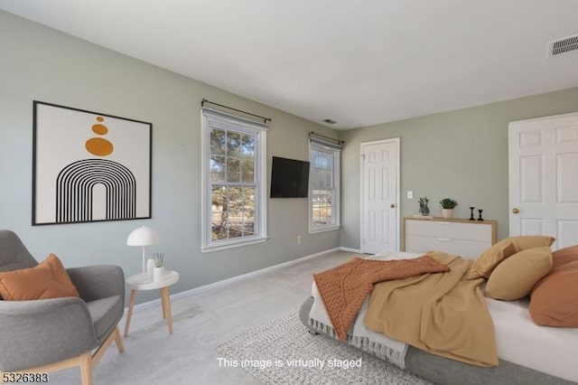 bedroom with light carpet, visible vents, and baseboards