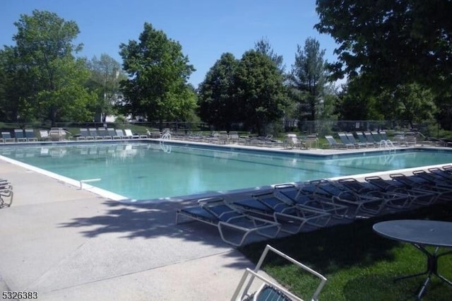 pool with a patio and fence