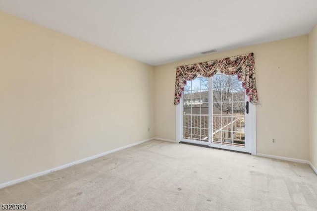 carpeted empty room featuring visible vents and baseboards