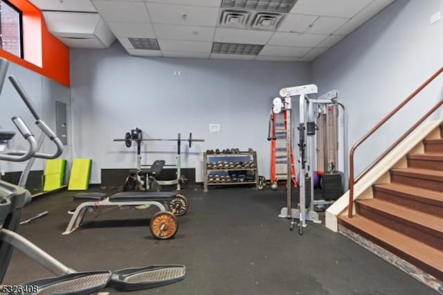 gym featuring a drop ceiling and electric panel