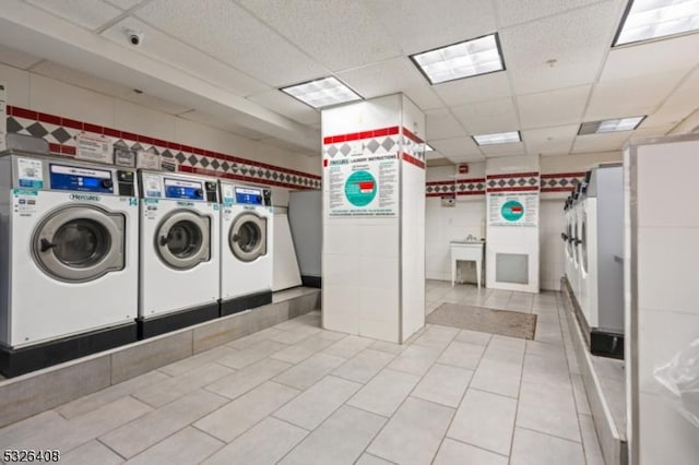 laundry area featuring light tile patterned floors and washing machine and dryer