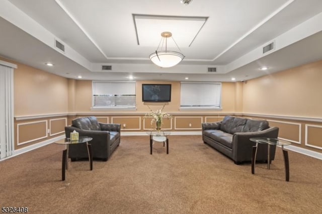 living room featuring a raised ceiling and carpet floors