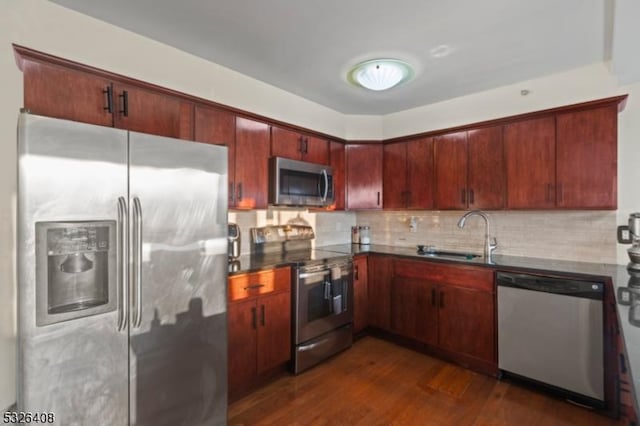 kitchen with tasteful backsplash, dark hardwood / wood-style flooring, sink, and stainless steel appliances