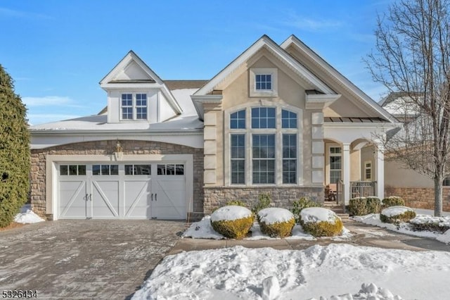 view of front of property with stone siding, driveway, and an attached garage