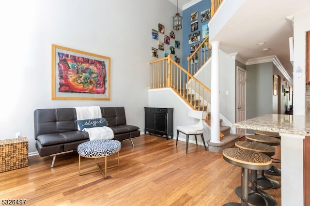 living room with ornamental molding and light hardwood / wood-style floors