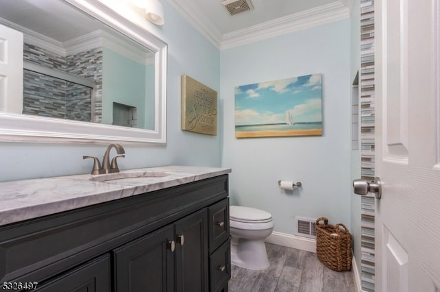 bathroom with a shower with shower door, toilet, vanity, and ornamental molding