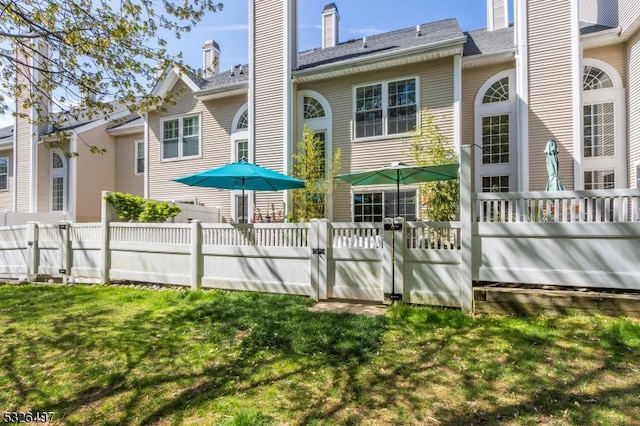 rear view of property with a lawn