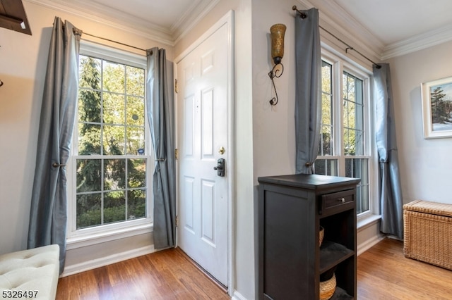 entryway with light wood-type flooring, a wealth of natural light, and ornamental molding