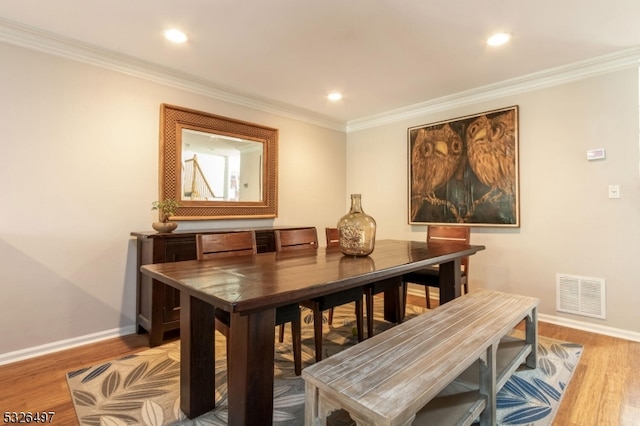 dining room featuring hardwood / wood-style floors and ornamental molding