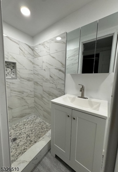 bathroom with vanity and tiled shower