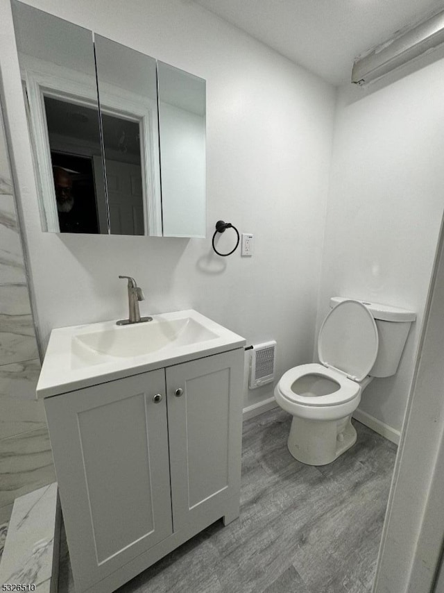 bathroom with vanity, toilet, and wood-type flooring