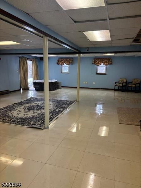 basement featuring tile patterned floors and a drop ceiling