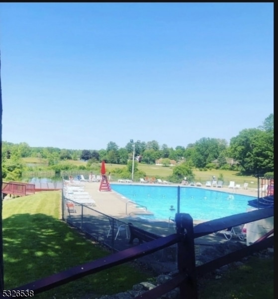 view of swimming pool with a yard and a water view