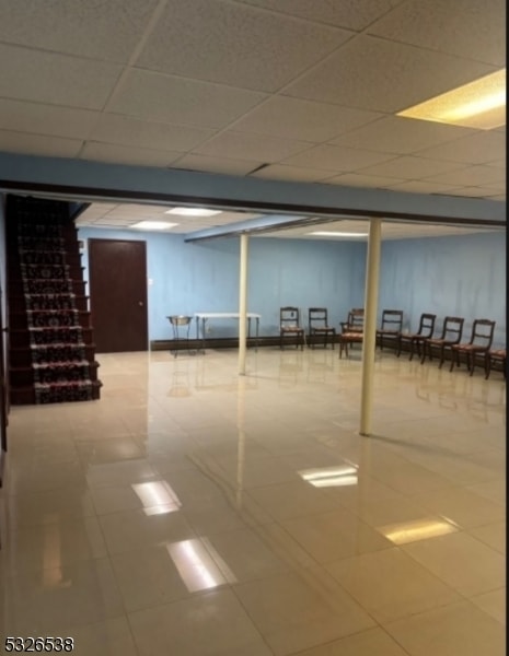 basement featuring tile patterned floors and a drop ceiling