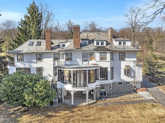 rear view of house featuring central AC and a sunroom