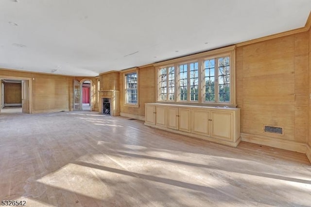 unfurnished living room with wooden walls