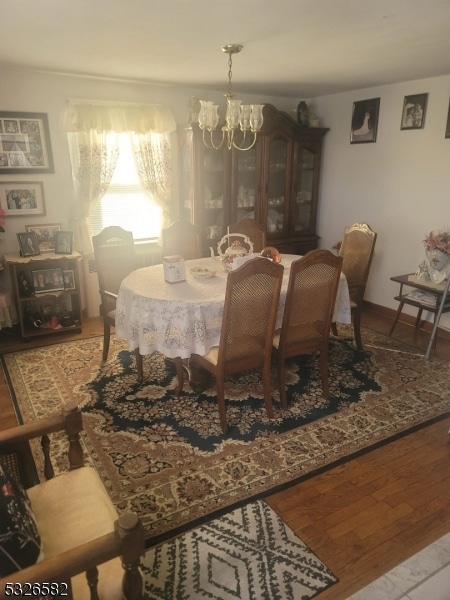 dining area with hardwood / wood-style floors and a notable chandelier