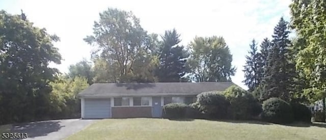 ranch-style home featuring a garage and a front lawn