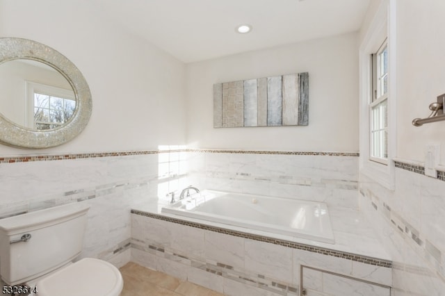 bathroom featuring tile patterned flooring, toilet, tile walls, and tiled tub