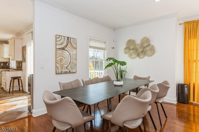 dining room featuring dark hardwood / wood-style floors, ornamental molding, and sink