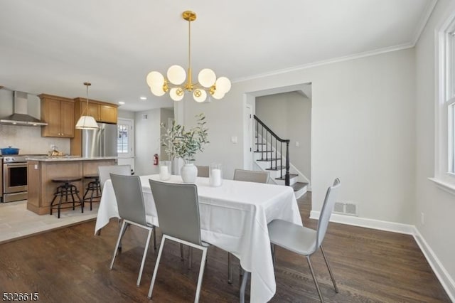 dining room featuring dark wood-type flooring, crown molding, and a chandelier