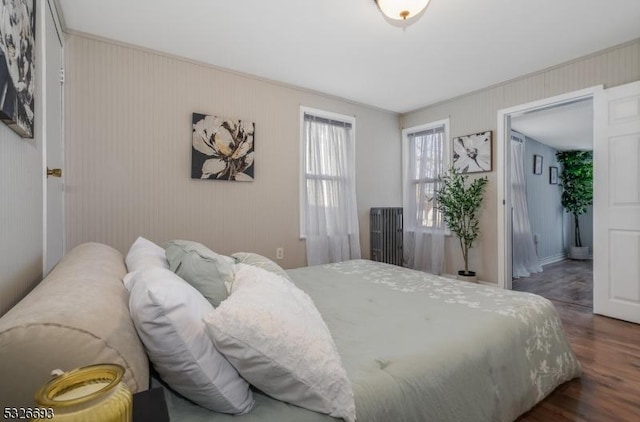 bedroom featuring crown molding and dark wood-type flooring