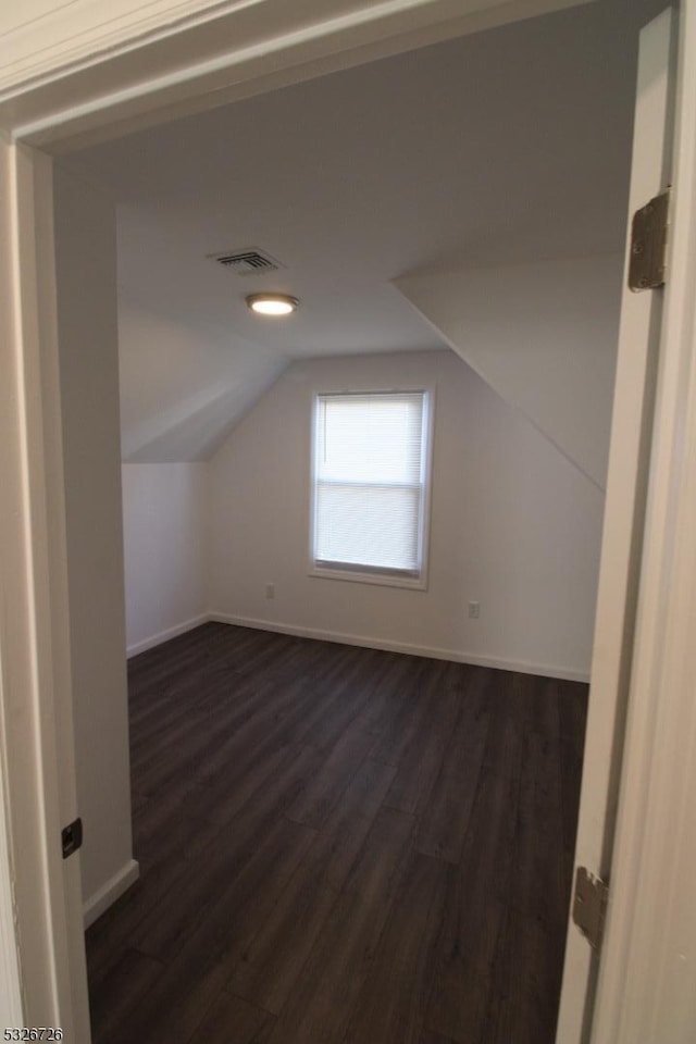 bonus room with dark hardwood / wood-style floors and lofted ceiling